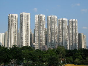 Cluster of high rise white apartment towers with balconies under a blue sky