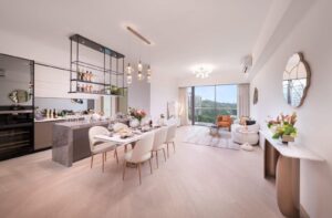 Open plan living and dining area with a marble kitchen island hanging pendant lights and a long dining table set for dinner
