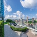 Rooftop terrace with outdoor seating glass front skyscraper on the left and a city skyline under a blue sky