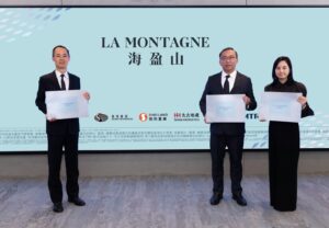 Three professionals in suits hold certificates while standing in front of a light blue backdrop that reads LA MONTAGNE with logos below