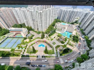 Aerial view of a dense cluster of high rise residential towers surrounding a landscaped courtyard with pools and sports courts