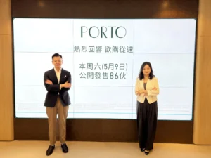 Two professionalsman in a suit and woman in a blazerstand in front of a large screen displaying PORTO and Chinese text