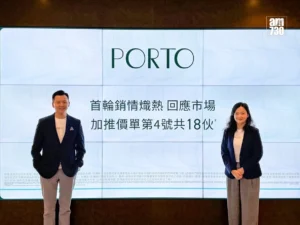 Two professionals stand in front of a large screen that reads PORTO with Chinese text logo top right posing for a presentation photo