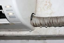 Close up of an air conditioner hose flexible insulated duct attached to a wall near the ceiling