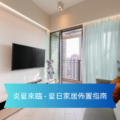 Living room with a wall mounted TV balcony door sheer turquoise curtains and a gray sofa with an orange pillow