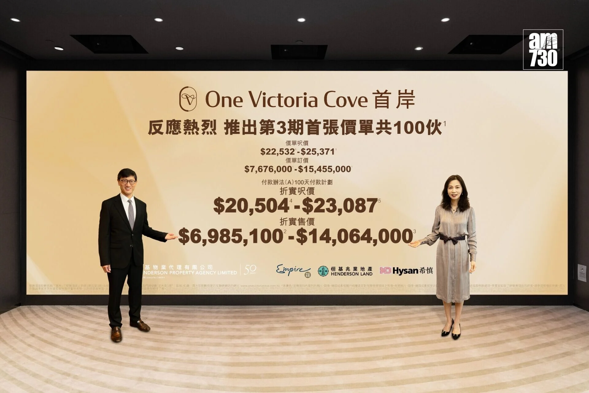 Two professionally dressed individuals stand at opposite ends of a large beige ad banner featuring Chinese text and English title “One Victoria Cove.”